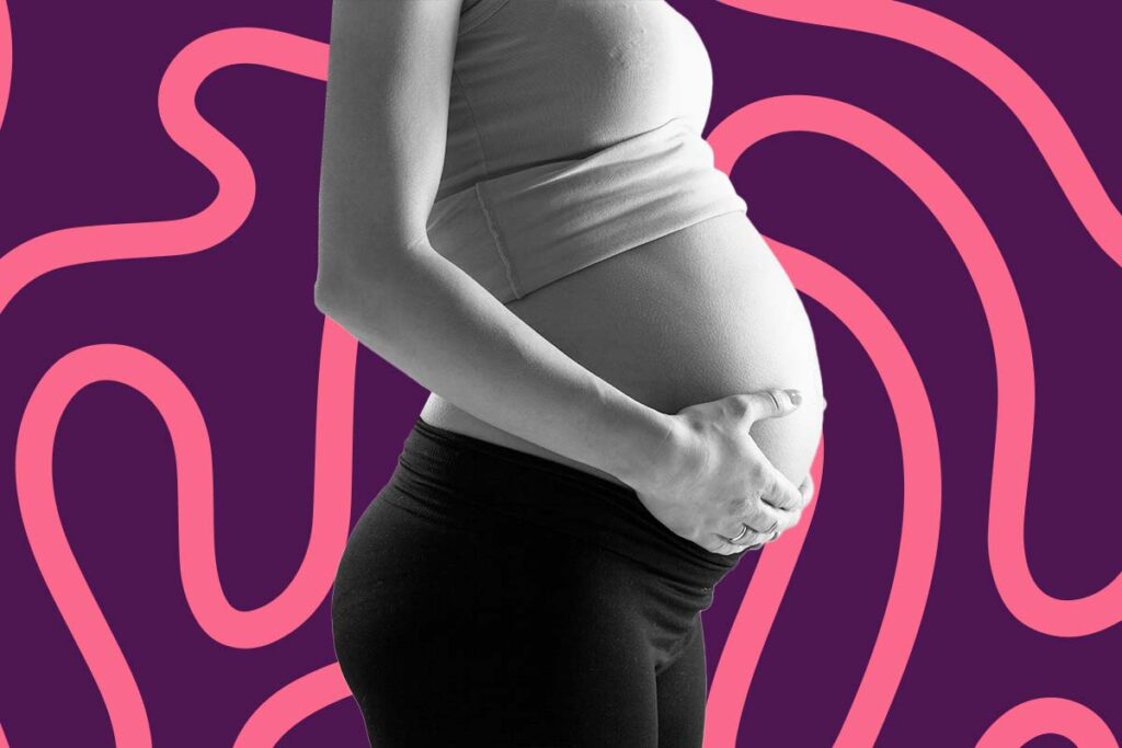 Mulher grávida com as mãos na barriga