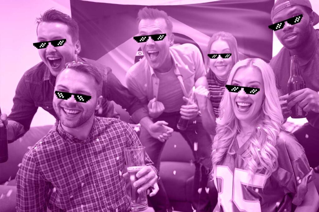 Seis pessoas de óculos escuros, algumas com copo de cerveja na mão, comemorando algo. Atrás delas, uma bandeira do Brasil.