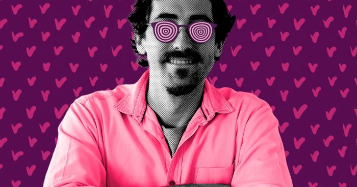 homem sorridente e de braços cruzados