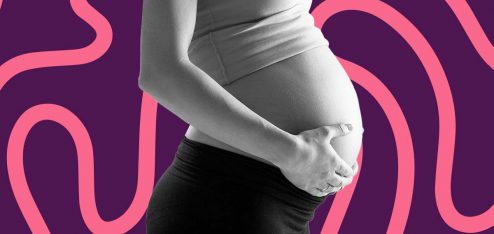Mulher grávida com as mãos na barriga