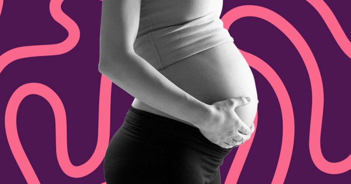 Mulher grávida com as mãos na barriga