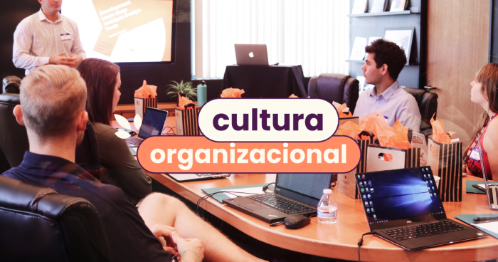 Pessoas em reunião em volta de uma mesa de madeira redonda. No título da imagem: "Cultura organizacional".