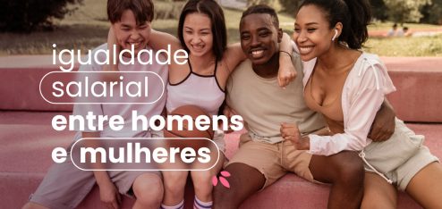 Quatro pessoas abraçadas em um parque. Elas estão sentadas e se apertando umas contra as outras. No título da imagem 'igualdade salarial entre homens e mulheres'.