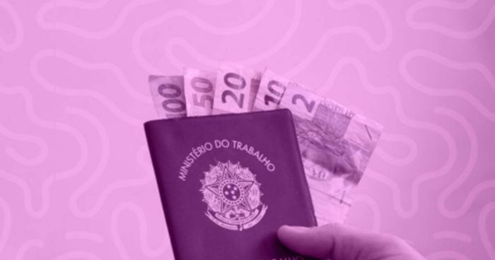 Na imagem há uma carteira de trabalho (CTPS), direito garantido pela CLT, com algumas notas de dinheiro dentro.