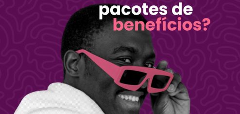 homem sorrindo enquanto segura óculos de sol, na cor rosa, próximo ao rosto